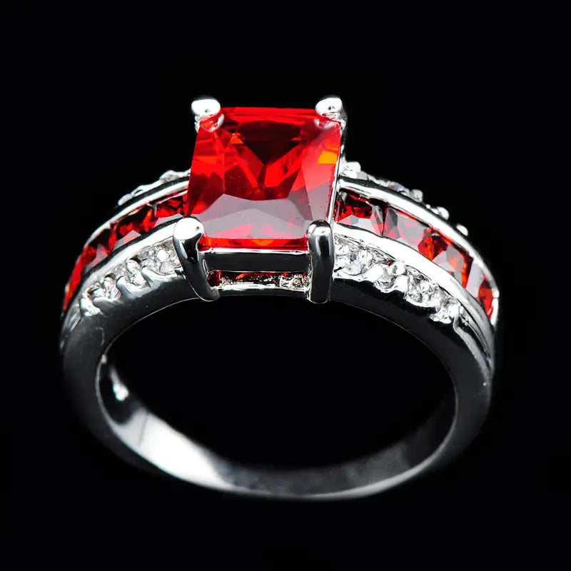 Anillo de plata con rubí dividido, estilo vástago dividido, marca Rose & Oliver, destacado en la imagen con detalles brillantes y acabado elegante.