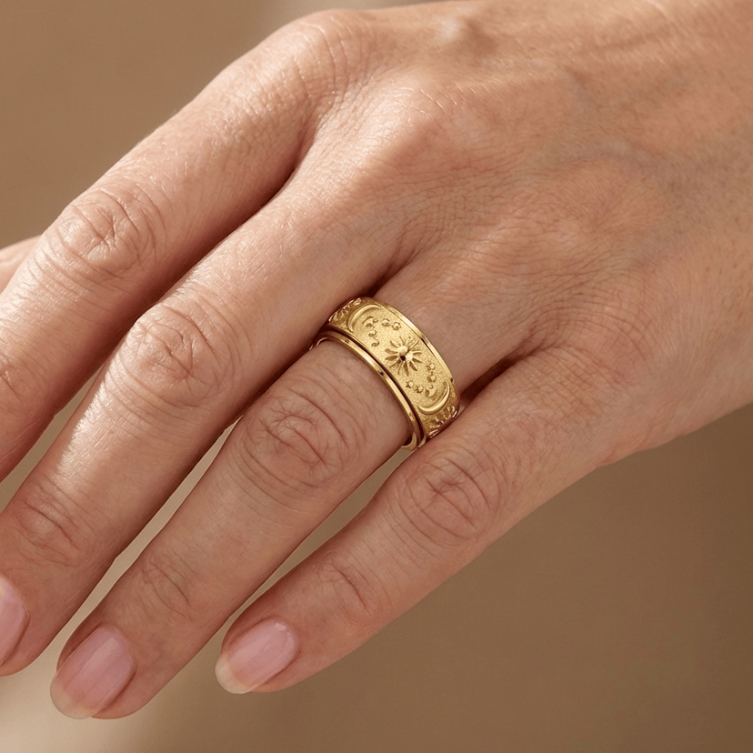 Anel rotativo celestial dourado da Rose & Oliver, com detalhes de estrelas e constelações, feito em metal dourado brilhante.