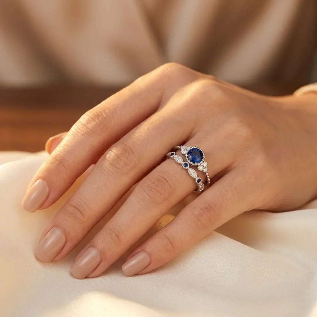 Anel de prata com halo de safira azul, design elegante da Rose & Oliver, mostrando o anel com detalhe em pedra central brilhante.