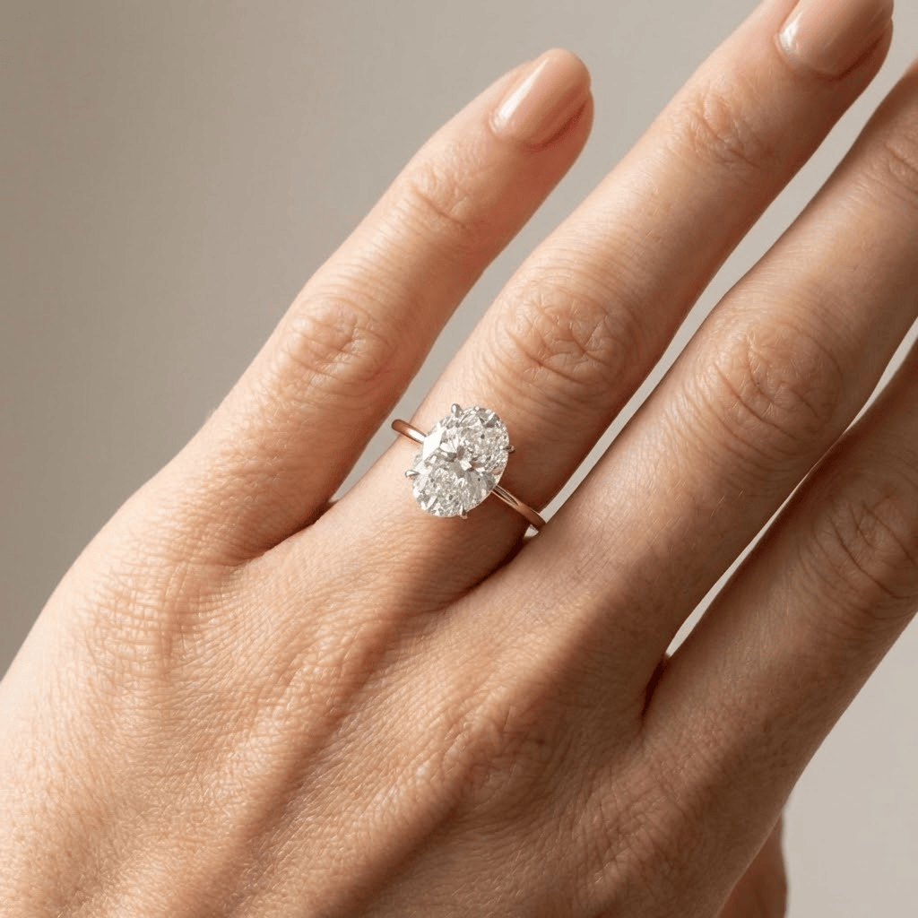 Anillo de diamante oval solitario Rose & Oliver con banda de oro, destacando el diamante central brillante y elegante.