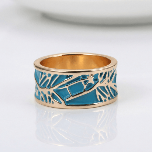 Anillo dorado rosé con turquesa y detalles místicos, de la marca Rose & Oliver, mostrando el diseño elegante y brillante.