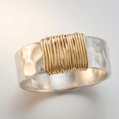 Anillo artesanal de plata con cordones enrollados, hecho por la marca Rose & Oliver, en primer plano con detalles visibles.