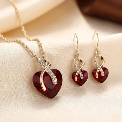 Conjunto de joyas Rose & Oliver con corazón torcido dorado y rubíes rojos, que incluye collar y aretes elegantes para ocasiones especiales
