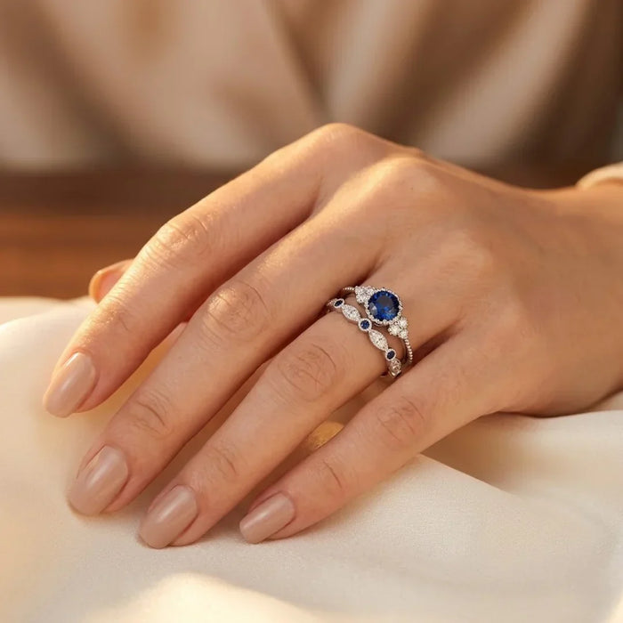 Anel de prata com halo de safira azul, design elegante da Rose & Oliver, mostrando o anel com detalhe em pedra central brilhante.