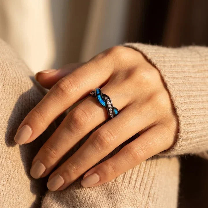 Anillo de acero plateado con acabado torcido e incrustaciones, de la marca Rose & Oliver, mostrado en primer plano con detalles brillantes.