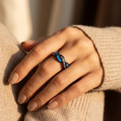 Anillo de acero plateado con acabado torcido e incrustaciones, de la marca Rose & Oliver, mostrado en primer plano con detalles brillantes.