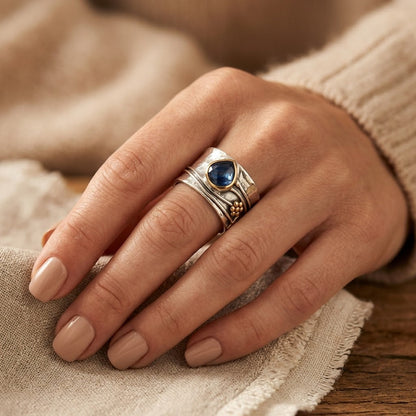Anel com acabamento em prata e ouro com detalhes de bezel, da marca Rose & Oliver, exibido com foco na textura e design elegante.