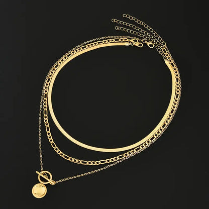 Collar dorado Rose & Oliver Savira con capas texturizadas y detalles de monedas destacados.
