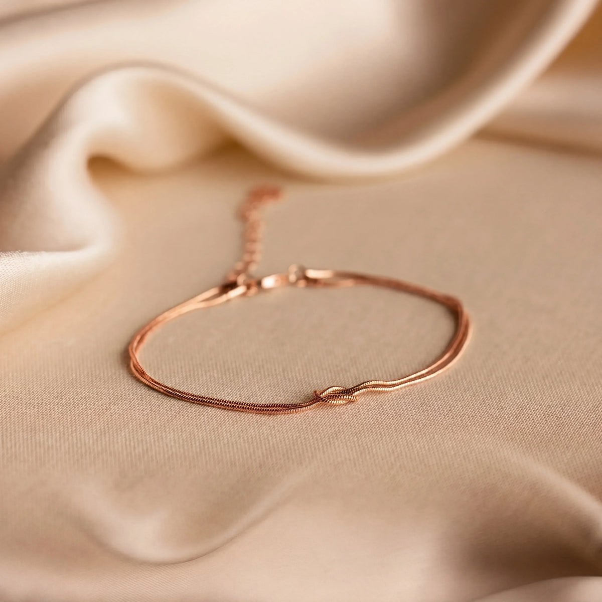 Pulseira Forever Knot da Rose & Oliver em tom dourado rosé, símbolo de conexão e amizade para casais, amigos e família.