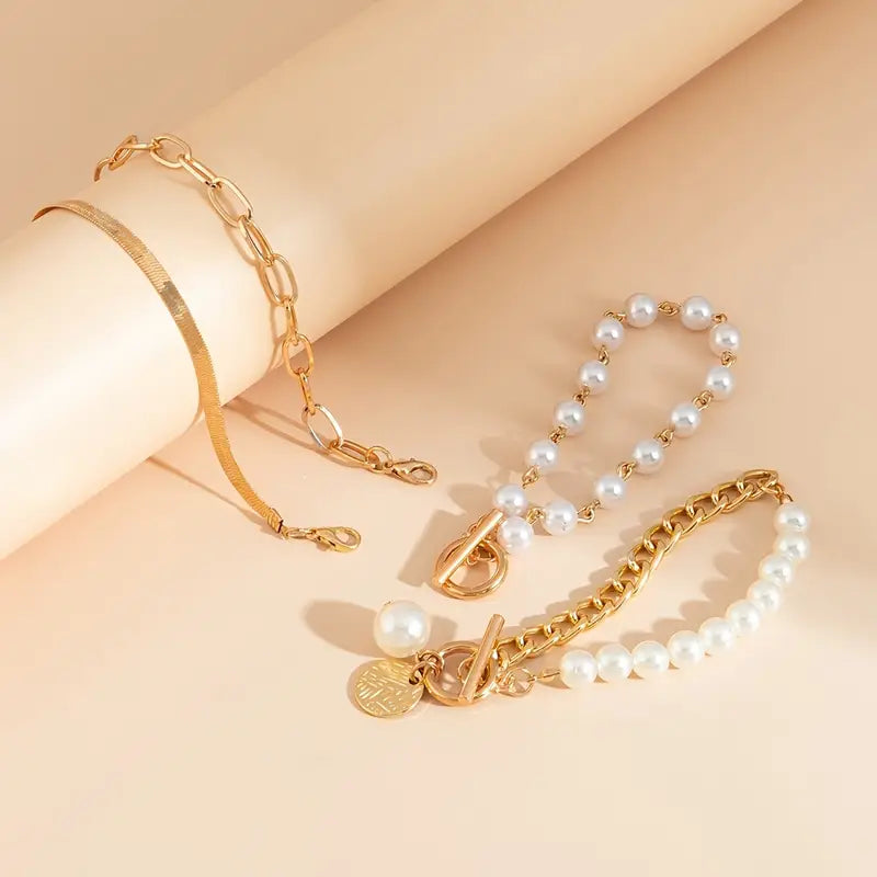 Set de 4 pulseras doradas con detalles de serpiente, perlas y eslabones, de Rose & Oliver, estilo elegante y sofisticado.
