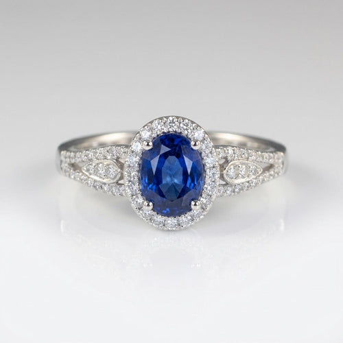 Vintage-Ring Rose & Oliver mit blauem Saphir-Halo und Silberdetails, Hervorhebung für das elegante Design und den strahlenden zentralen Stein.