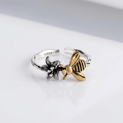 Anel ajustável Rose & Oliver de prata com abelha e flor detalhadas, delicado e elegante para uso diário.