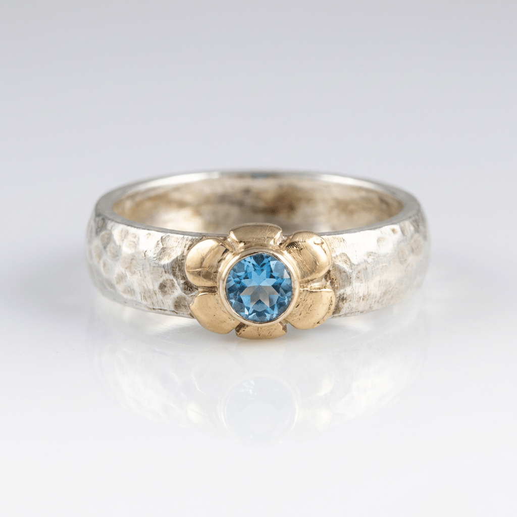 Anillo de plata de dos tonos con topacio azul hecho a mano, de la marca Rose & Oliver, mostrado en la imagen.