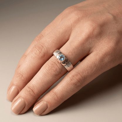 Anillo de plata de dos colores con topacio azul hecho a mano, de Rose & Oliver, mostrado en la imagen.