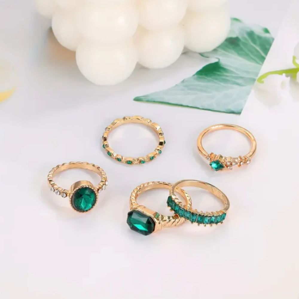 Set de joyas Zarina con anillos de esmeralda y oro, diseño elegante de la marca Rose & Oliver, detalles en piedras preciosas.